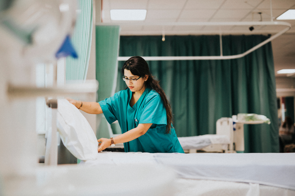 nurse making hospital bed