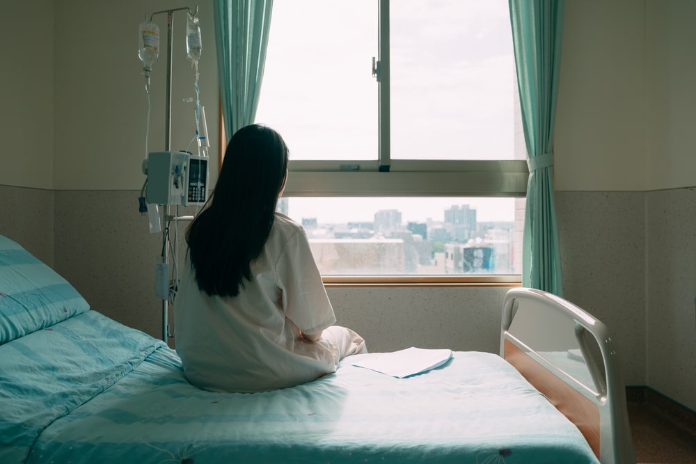 woman sitting on hospital bed